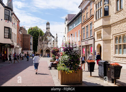 View to old 16thc Market Cross (1501) with people shopping in small city centre in summer. East Street Chichester West Sussex England UK Britain Stock Photo
