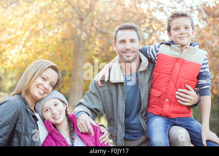 Portrait smiling family in front of tree with autumn leaves Stock Photo