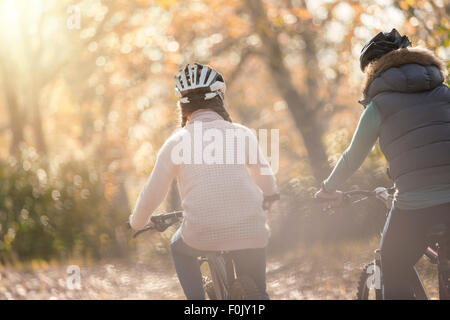 Mother and daughter bike riding in woods Stock Photo