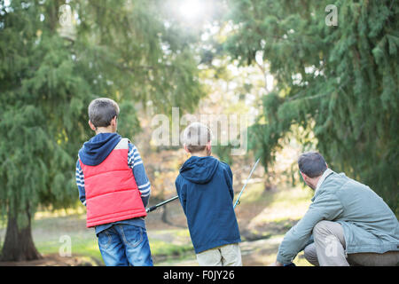 Father and sons fishing in woods Stock Photo