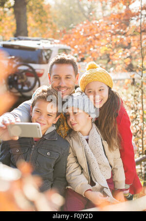 Family taking selfie among autumn leaves Stock Photo