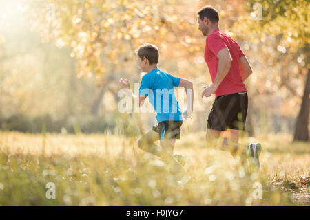 Father and son jogging in park Stock Photo