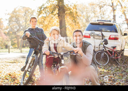 Portrait father and sons with bicycles in autumn park Stock Photo