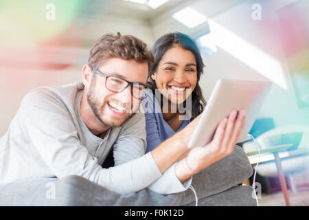 Portrait laughing couple using digital tablet Stock Photo