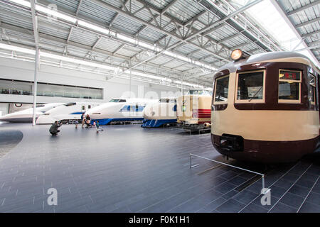 Japan, Nagoya, Railway park. Shinkansen Museum. Nearest is a Class Moha 52 electric railcar and beyond, an express and four different bullet trains. Stock Photo