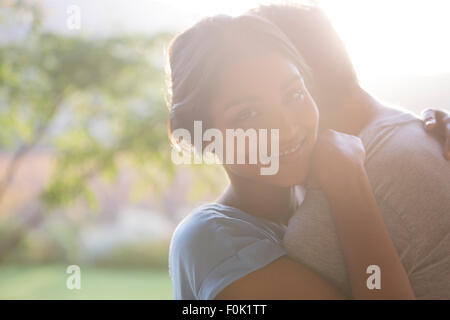 Portrait smiling woman hugging man outdoors Stock Photo