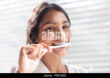 Close up portrait smiling woman brushing teeth Stock Photo