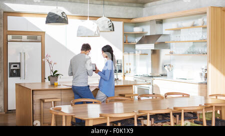 Couple using digital tablet in kitchen Stock Photo
