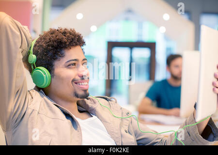 Creative businessman listening to headphones and using digital tablet Stock Photo