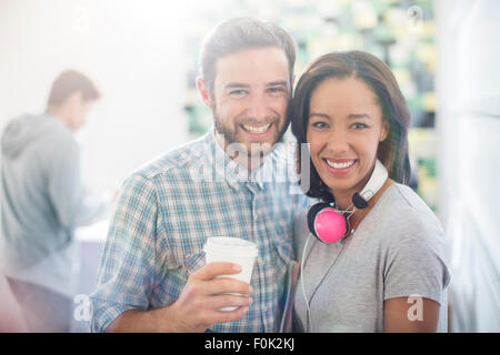 Portrait smiling creative business people with headphones and coffee Stock Photo