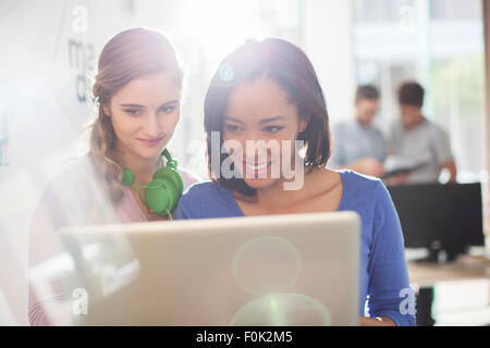 Creative businesswomen with headphones using digital tablet Stock Photo