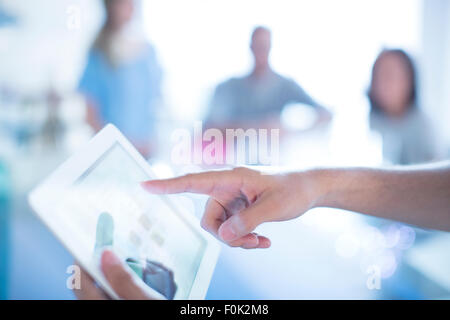 Close up businessman pointing to digital tablet in meeting Stock Photo
