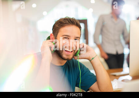 Portrait enthusiastic creative businessman listening to headphones in office Stock Photo
