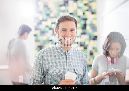 Portrait confident creative businessman drinking coffee in office Stock Photo