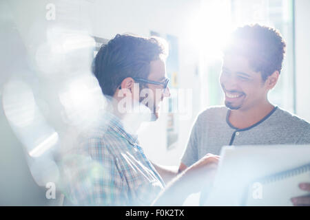 Smiling creative businessmen using digital tablet in sunny office Stock Photo