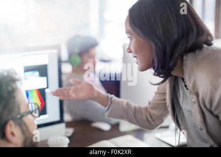 Creative businesswoman gesturing at computer in office Stock Photo