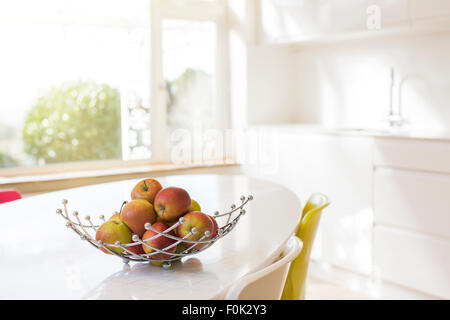 Apples in wire basket on modern kitchen table