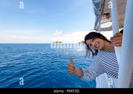Tourist woman smiling happily with thumb up praising the beautiful of the sea at Mu Koh Similan island National Park, Phang Nga Stock Photo