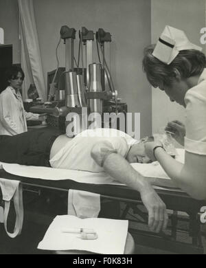 This image captures the process of an X-ray being taken, likely in a medical setting. X-ray technology is used for diagnostic imaging to view the internal structure of the body. Stock Photo