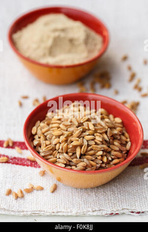Spelt grains and flour in bowls Stock Photo
