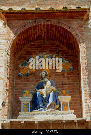 Set in its niche in the gateway to the Abbazia di Monte Oliveto Maggiorre, near Siena, is this della Robbia terracotta. Stock Photo