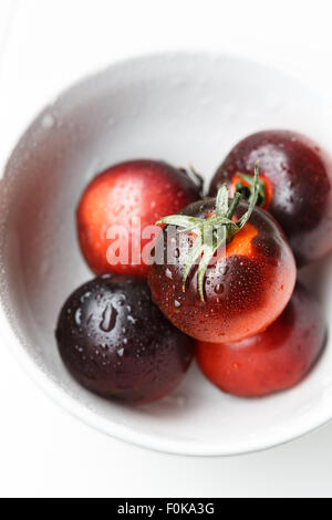 Black tomatoes in a white bowl Stock Photo