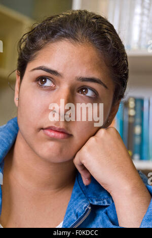 School Library  teenage senior girl school student deep in thought gazes out of school library window Stock Photo