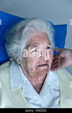 Comfort grief grieving Apprehensive concerned elderly woman with comforting hand of carer touching her cheek Stock Photo