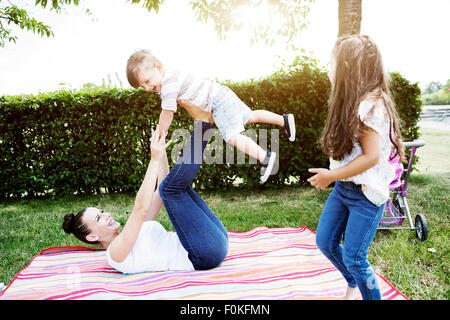 Woman balancing her little son on her feet Stock Photo