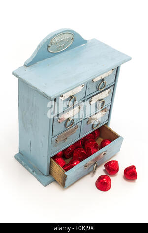Antique blue box with red candies, isolated on white. Stock Photo