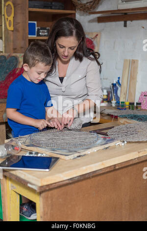 Mother and son doing crafts in home garage Stock Photo
