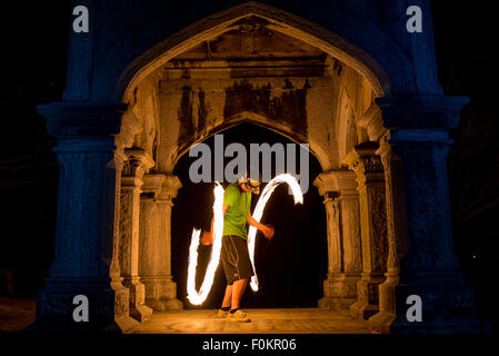 A college student spins and juggles fire in Oakwood Cemetery in Syracuse, New York. Stock Photo