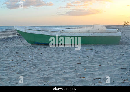 Old fisherman wooden boat sitting at a beach in Panama at sunset Stock Photo