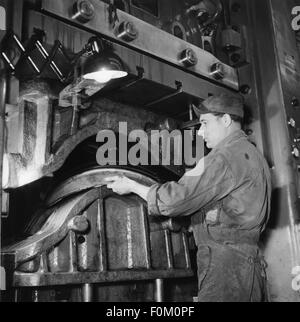 1950s, historical, male workers at machines repairing or retreading ...