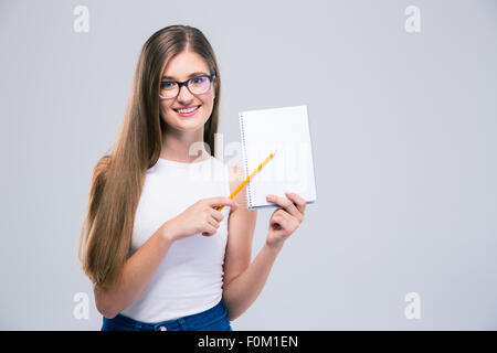Portrait of a smiling female teenager showing blank notebook isolated on a white background Stock Photo