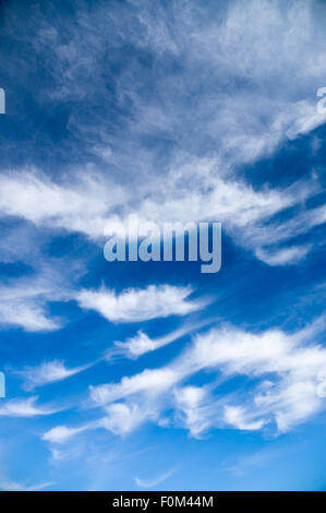 Cirrus and stratus clouds against bright blue sky, vertical wide angle view Stock Photo