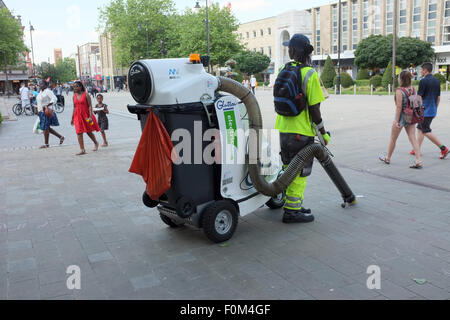 Male operative using a glutton electric waste street vacuum cleaner in Bolton, Lancashire, England UK Stock Photo