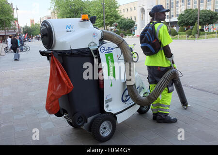 Male operative using a glutton electric waste street vacuum cleaner in Bolton, Lancashire, England UK Stock Photo