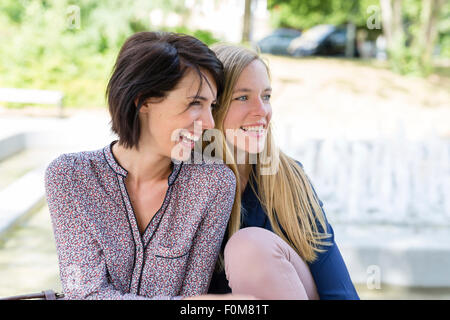 Two girlfriends laugh together and talk Stock Photo