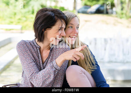 Two girlfriends laugh together and talk Stock Photo