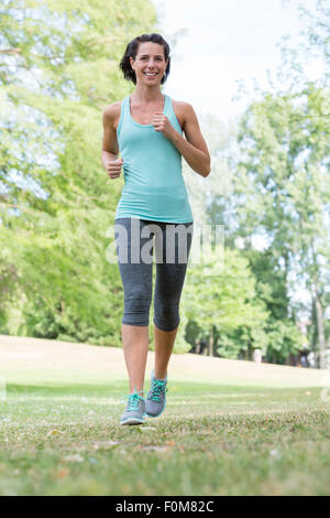 Woman jogging through the park Stock Photo