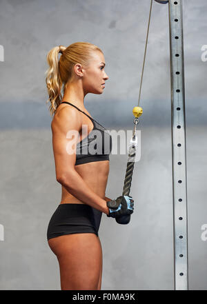 Young Beautiful Sporty Woman Flexing Biceps Closeup on Gray