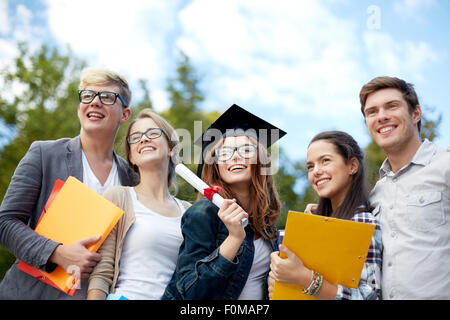 group of smiling students with diploma and folders Stock Photo