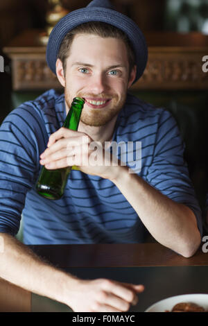 happy young man drinking beer at bar or pub Stock Photo