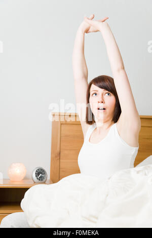 Young woman waking up in her bed Stock Photo