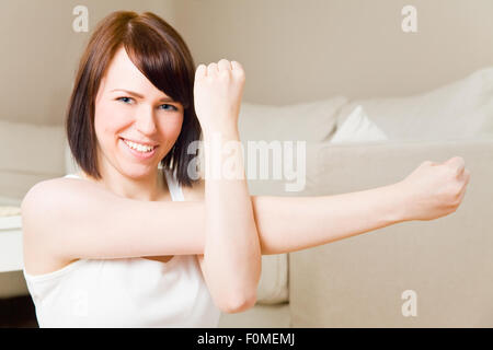 Young woman doing exercises in her living room Stock Photo