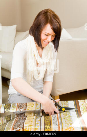 Young woman packing presents in her living room Stock Photo