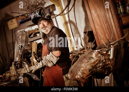 Welder wearing face mask and protective gloves in factory Stock Photo