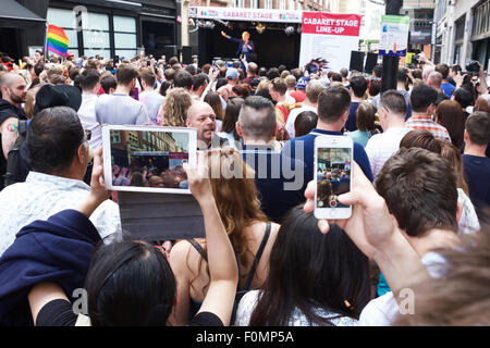 Apple iPad tablet computer & mobile phone / smart phone recording an event / street performance in Soho, London, England, UK. Stock Photo