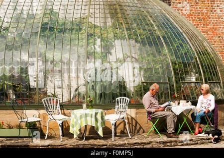 A couple relaxing over a pot of tea at the tea garden next to the Italianate greenhouse in George VI Park, Ramsgate. Stock Photo